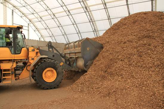 Bagger schiebt das Altholz zusammen